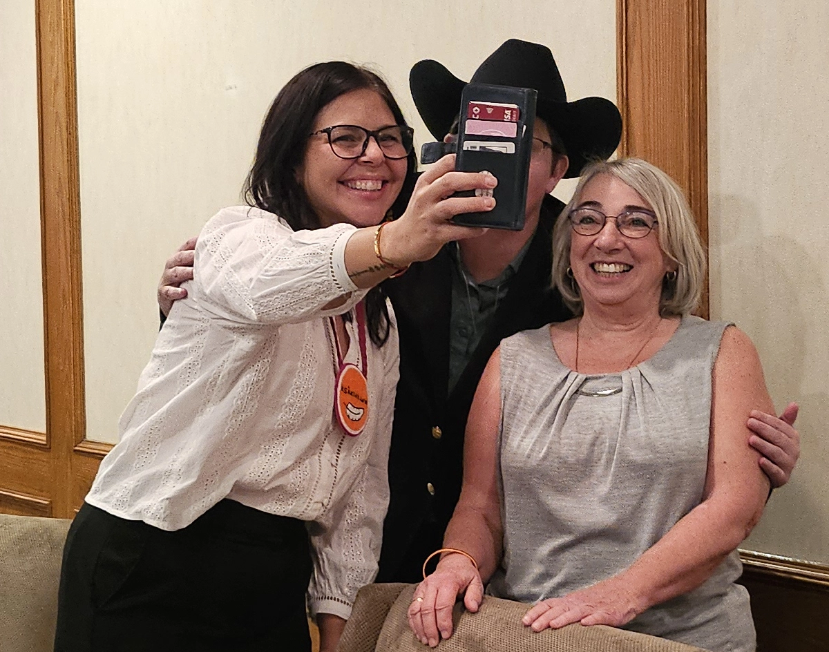 Three speakers at the “Accidental Advocate” event in St. Albert taking a selfie together and smiling.