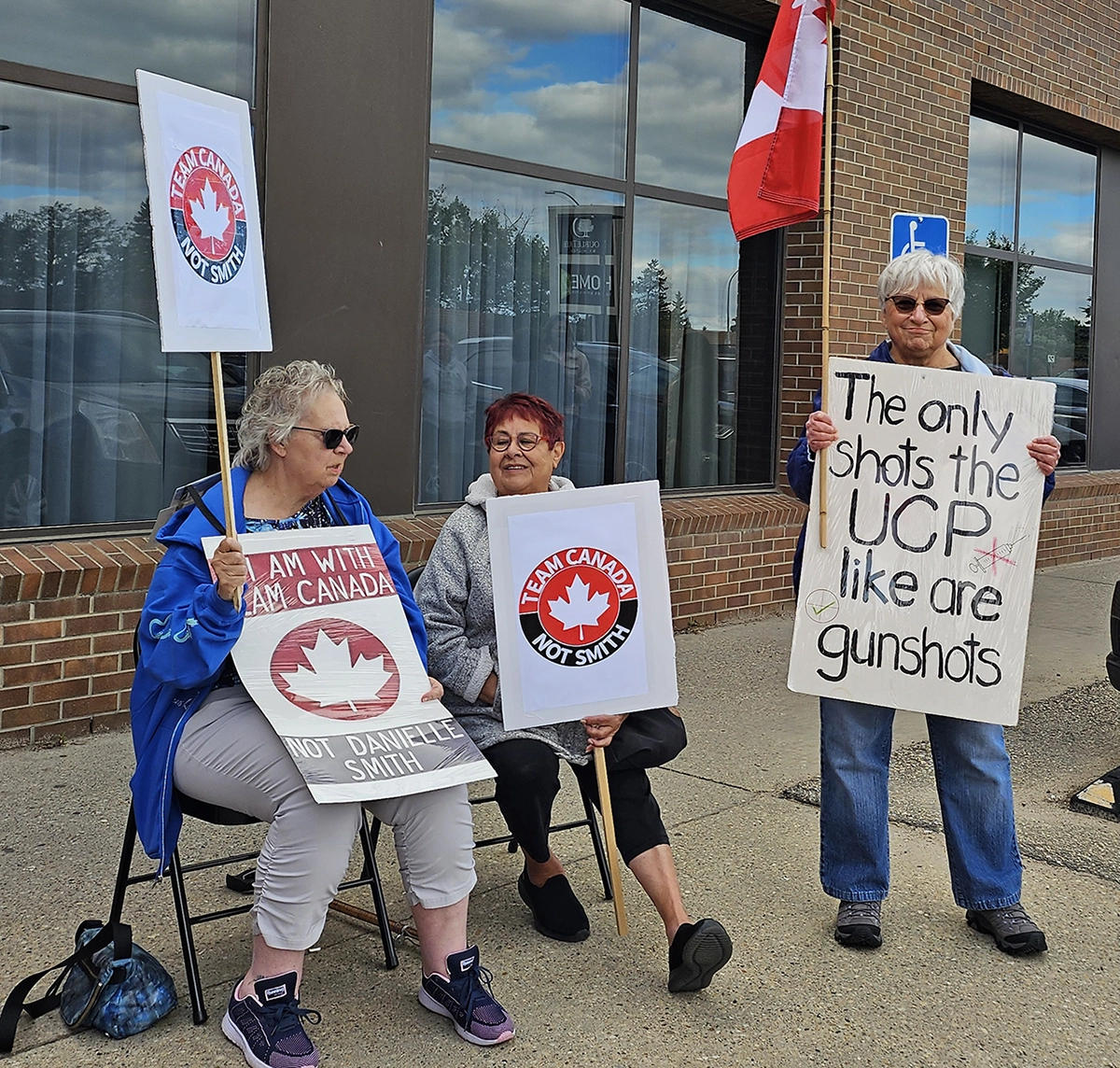 Protest signs reading “Team Canada Not Smith” and other messages at an Alberta Next town hall protest in Edmonton on August 14, 2025