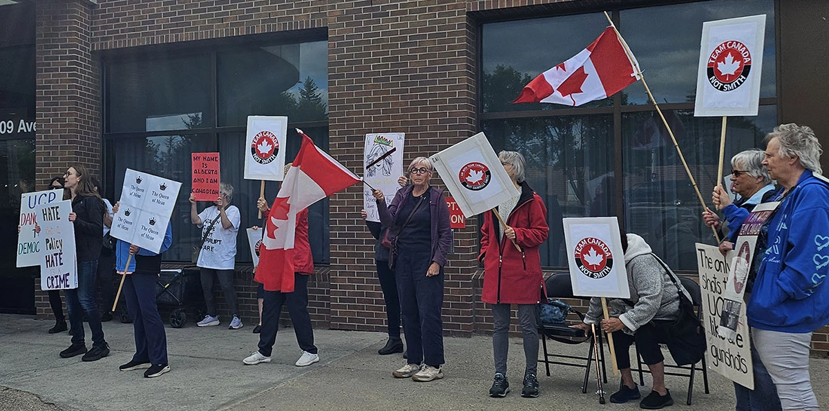 Participants holding signs at an Alberta Next town hall protest in Edmonton on August 14, 2025
