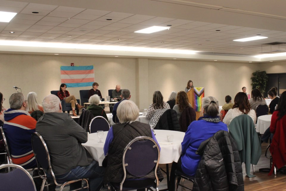 Audience attending a community dialogue event in St. Albert with panel discussion at the front of the room